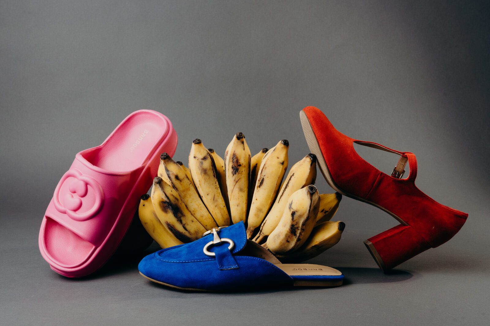 Pink slides, a blue loafer and a red heel with bananas