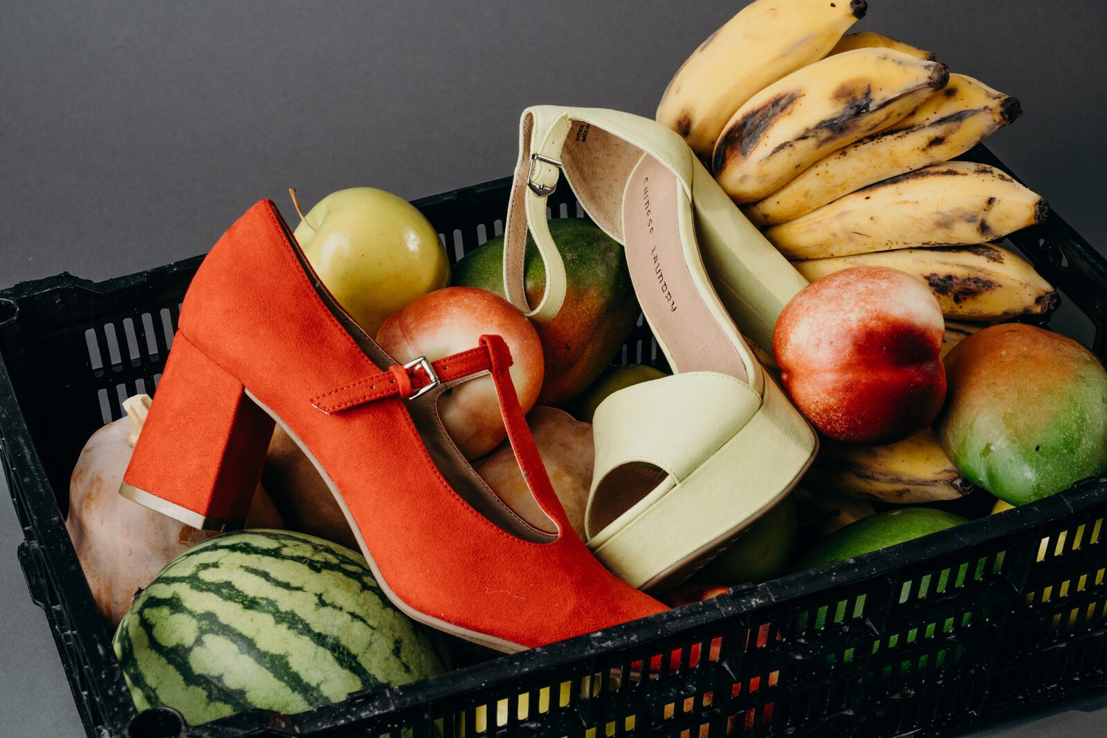 Red block heel in a crate of fruit
