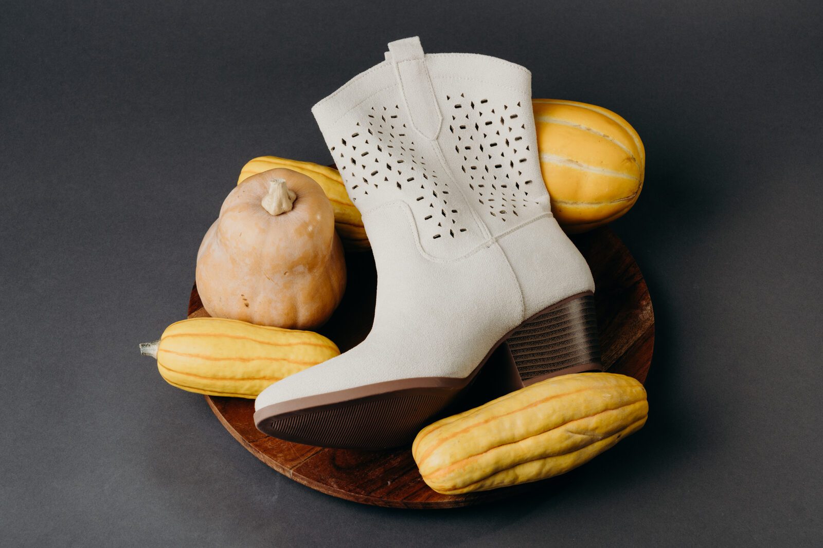 White western boot on a wooden plate of squash